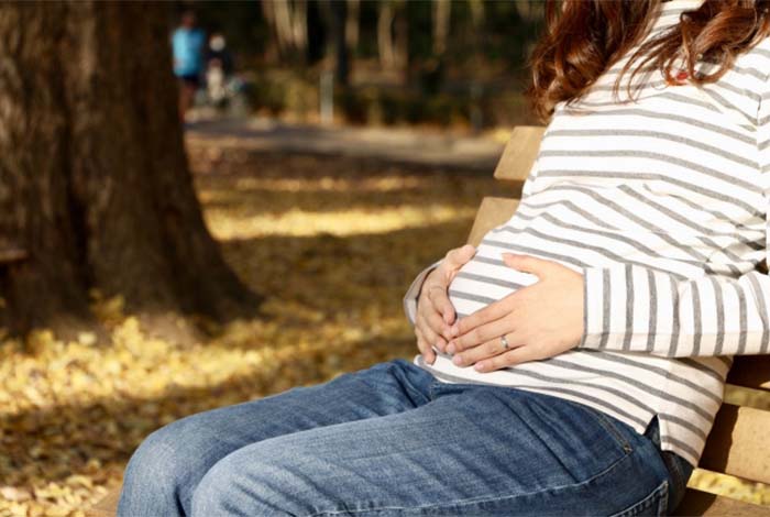 公園に座る妊婦